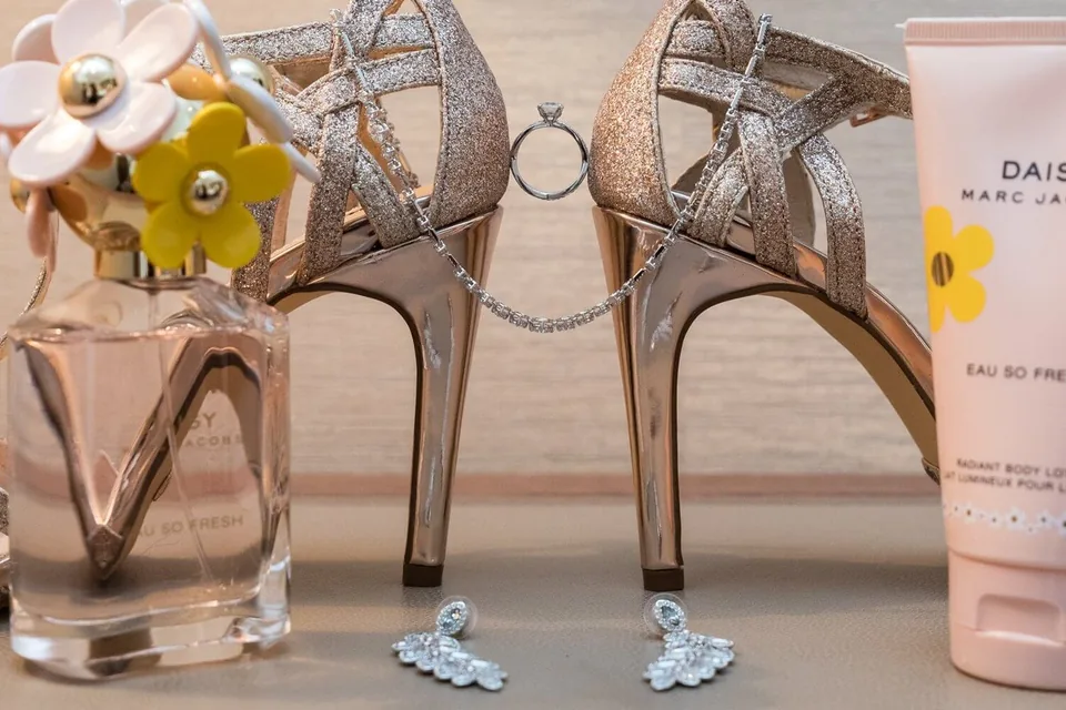 Bridal shoes, perfume and earrings arranged as a detail