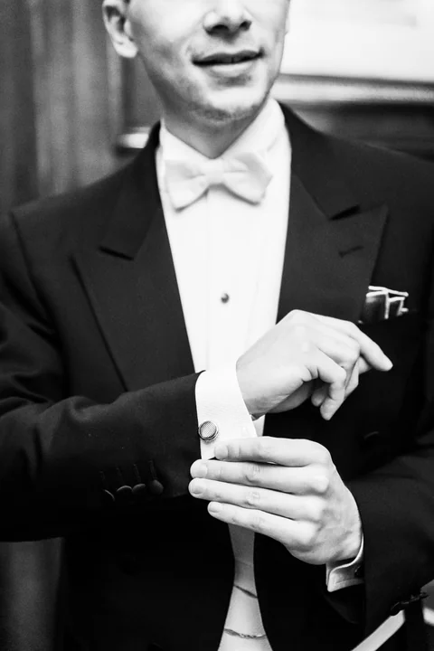 Elegantly dressed groom adjusting his cuff