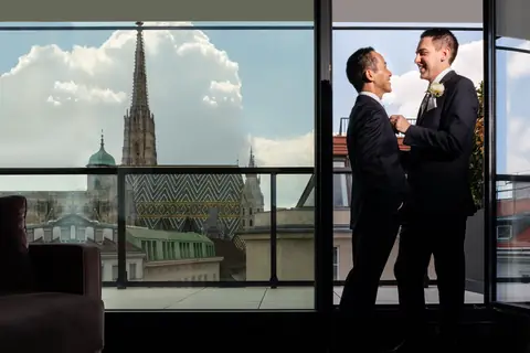 Die beiden Bräutigame am Fenster der Hotelsuite, dahinter der Stephansdom
