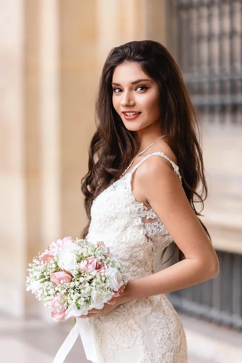 Bride with her bouquet in the arcades of Vienna City Hall