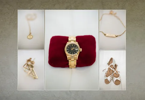 Detailaufnahme der Braut-Accessoires: goldene Armbanduhr und Schmuck auf rotem Samt