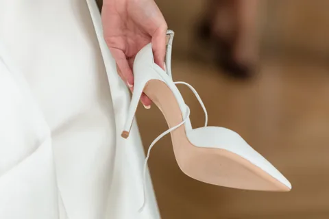 Brautschuh in der Hand der Braut vor dem Ankleiden