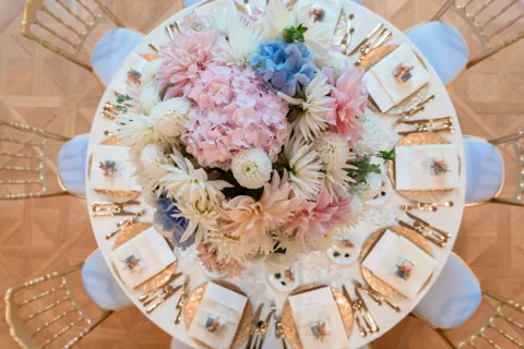 Gedeck der Hochzeitstafel von oben mit Blumenschmuck