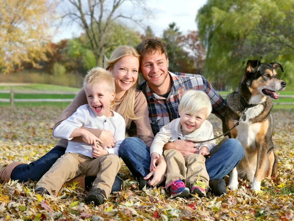 Family with two children and a dog in an autumnal park