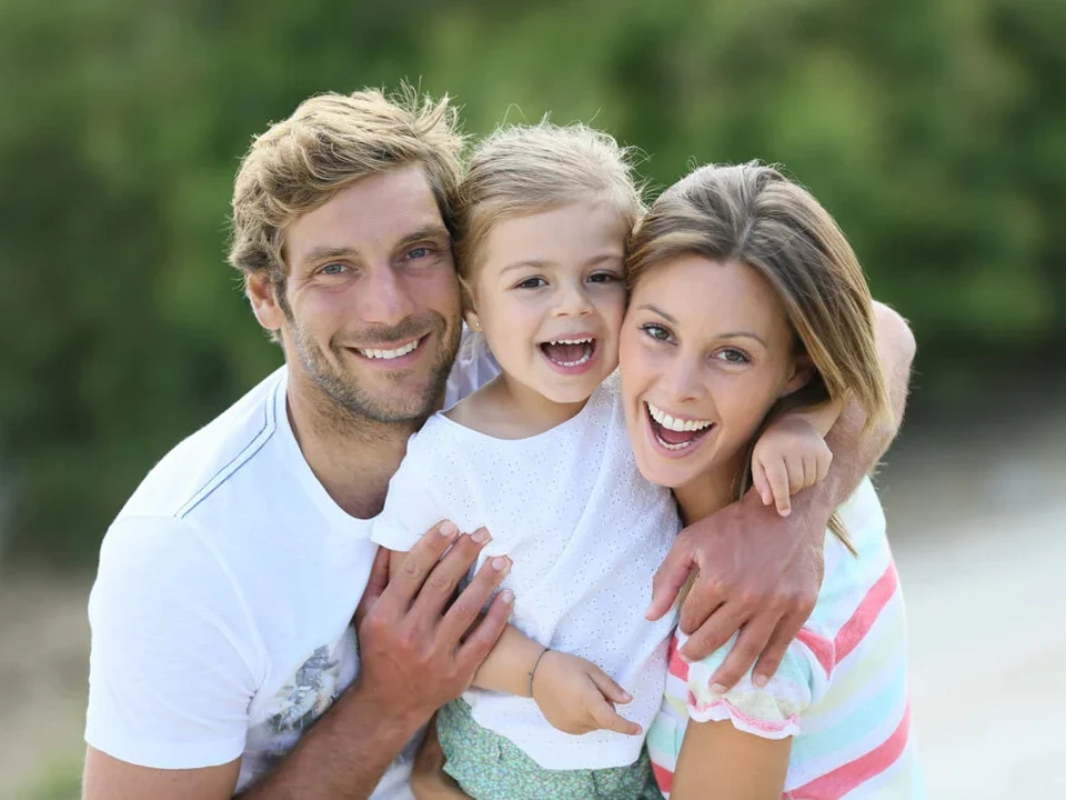 Parents with their daughter, a summery family portrait outdoors