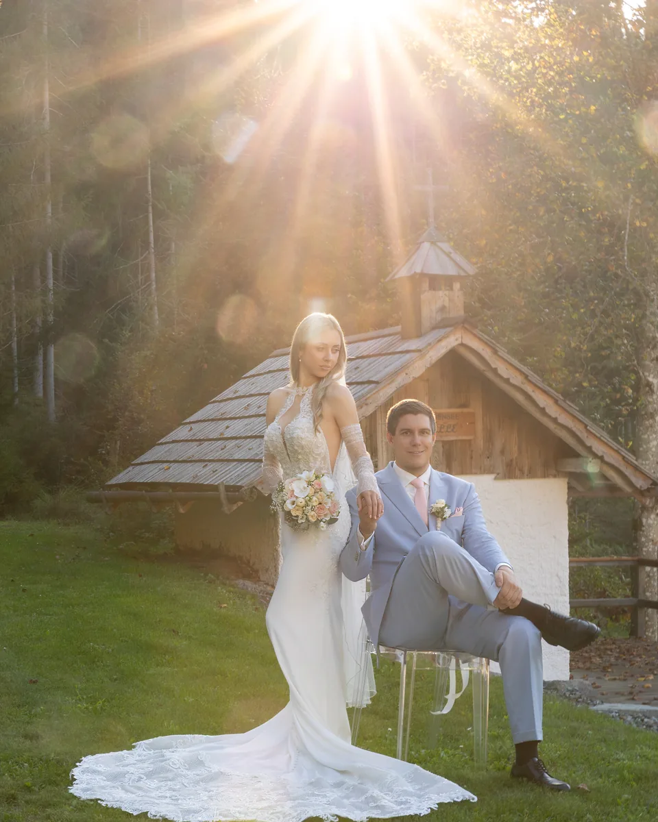 Hochzeitspaar im Gegenlicht der tiefstehenden Sonne vor der Kapelle am Haidensee
