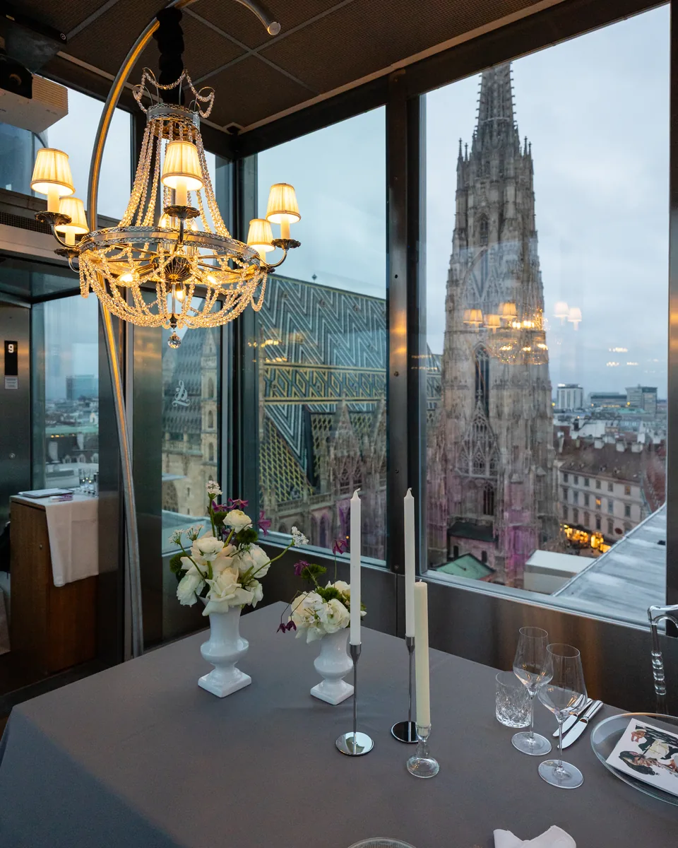 Kristallluster und gedeckte Tafel, durch das Fenster der Südturm des Stephansdoms
