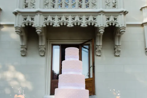 Fünfstöckige Hochzeitstorte mit Wunderkerzen vor der neogotischen Fassade von Schloss Hernstein