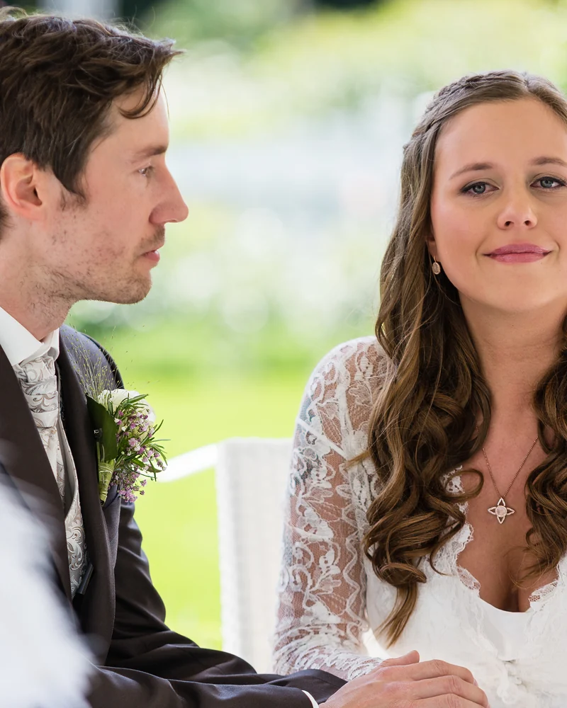 Hochzeitspaar bei einer Trauung im Grünen, weiches Frühlingslicht