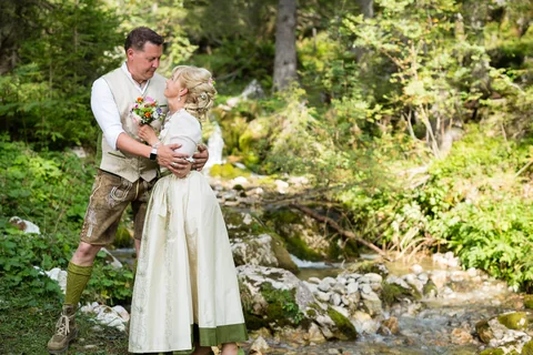 Wedding couple in traditional dress at the edge of the forest in Austria