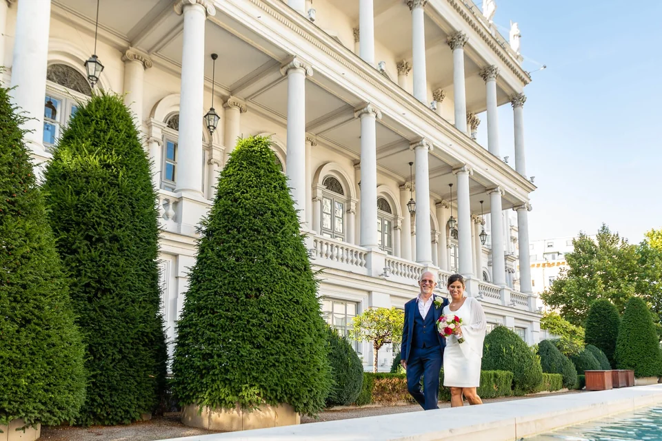 Wedding couple walking in the private garden of Palais Coburg in Vienna
