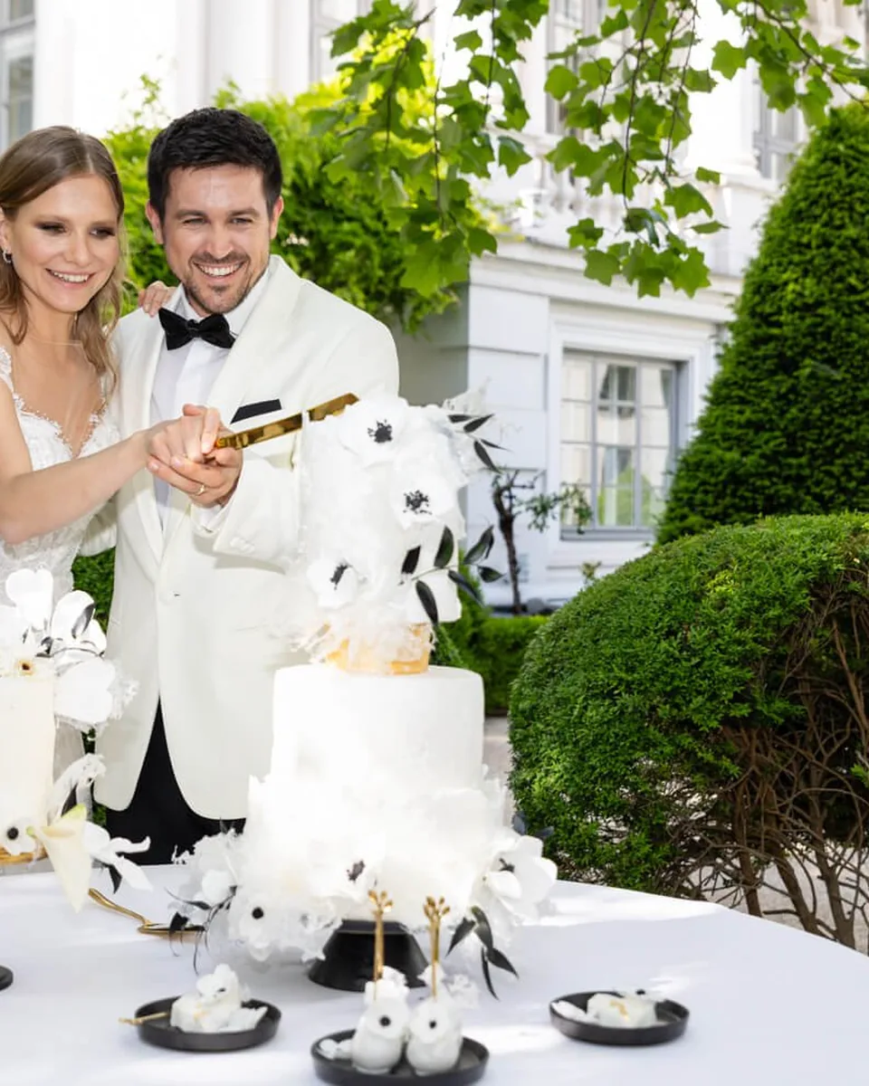 Wedding couple cutting the cake in the garden of Palais Coburg