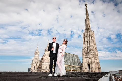 Wedding couple posing on the roof in front of St. Stephen's Cathedral