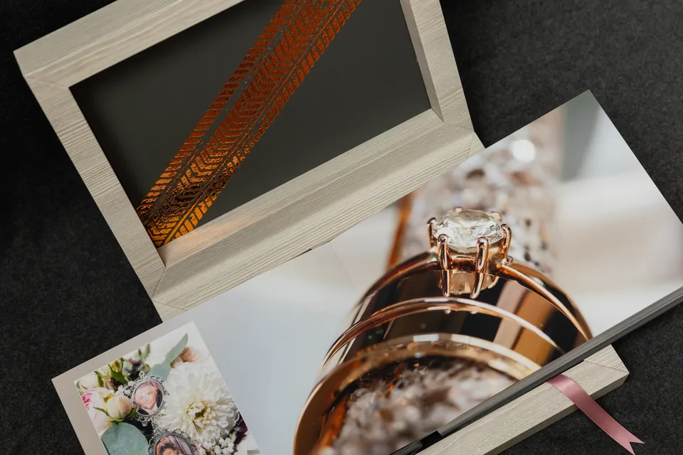 Open album spread showing a close-up photo of the wedding rings