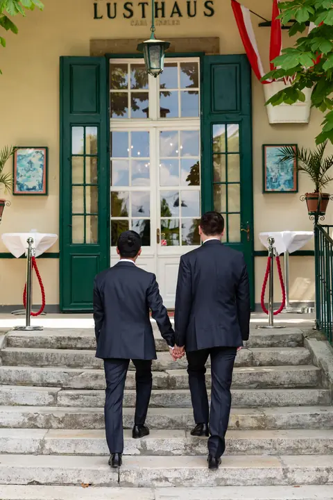 Die Bräutigame gehen Hand in Hand die Stufen zum Lusthaus hinauf