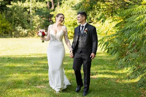 Wedding couple walking hand in hand through Schönbrunn palace park