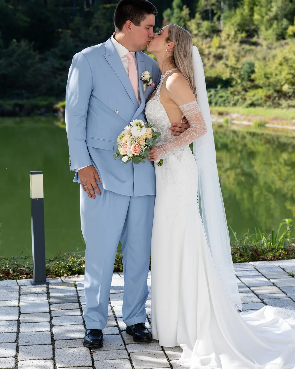 Hochzeitspaar küsst sich nach der Trauung auf dem Steinweg am Ufer des Haidensees