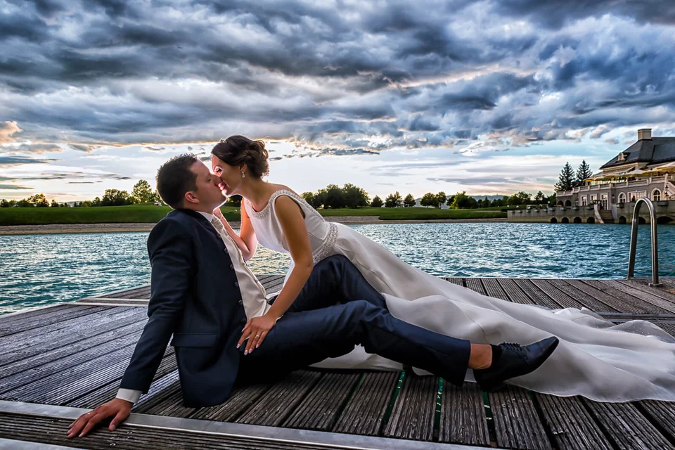 Hochzeitspaar auf einem Steg vor dramatischem Abendhimmel