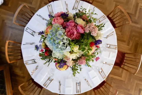 Runder Tisch mit bunten Blumen von oben im Lusthaus