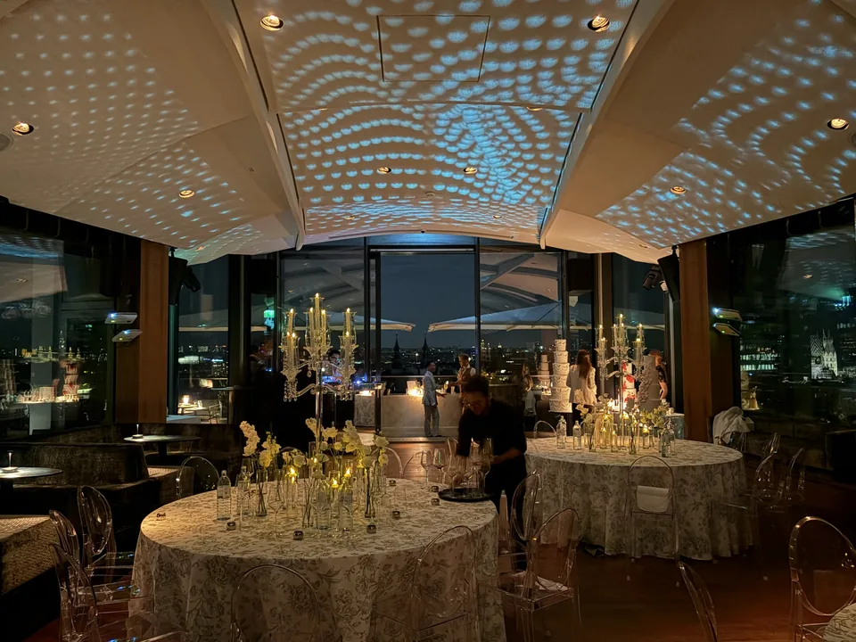Main room of Juwel Vienna in the evening with set tables and illuminated ceiling