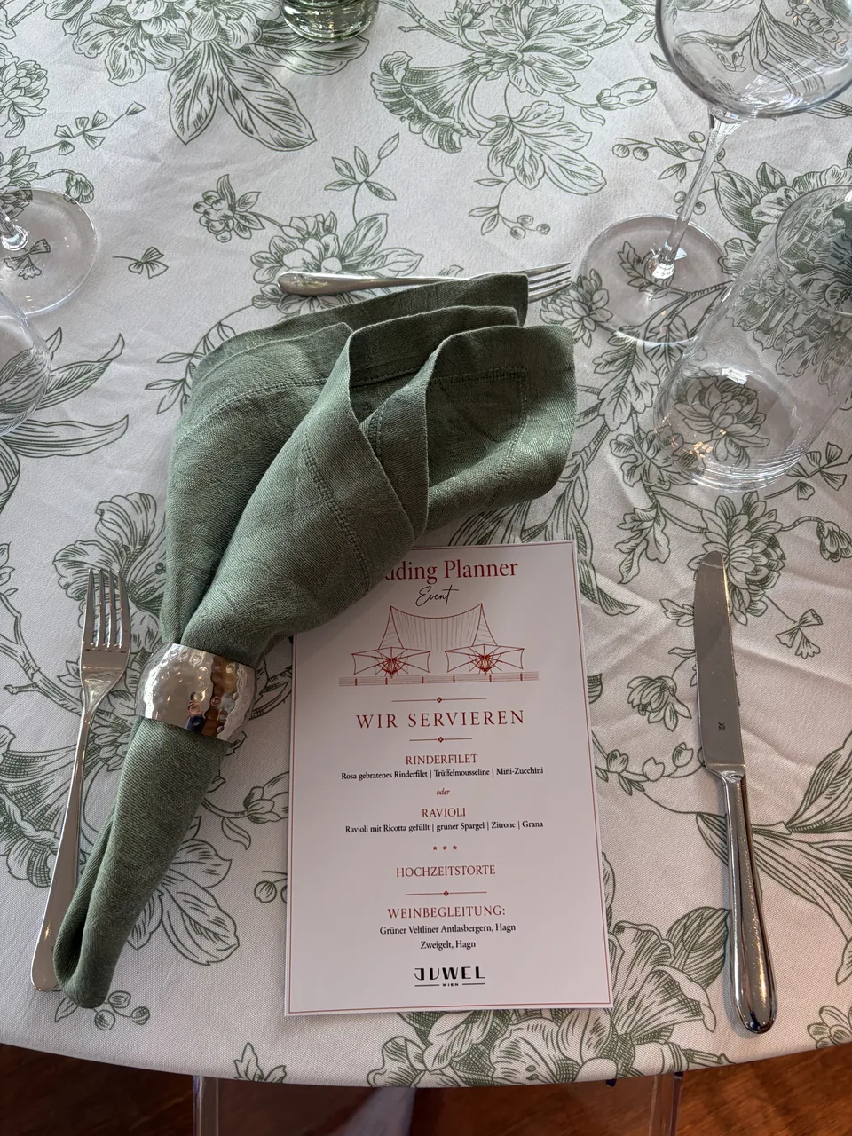 Place setting with napkin, napkin ring and menu card on patterned table linen at Juwel Vienna