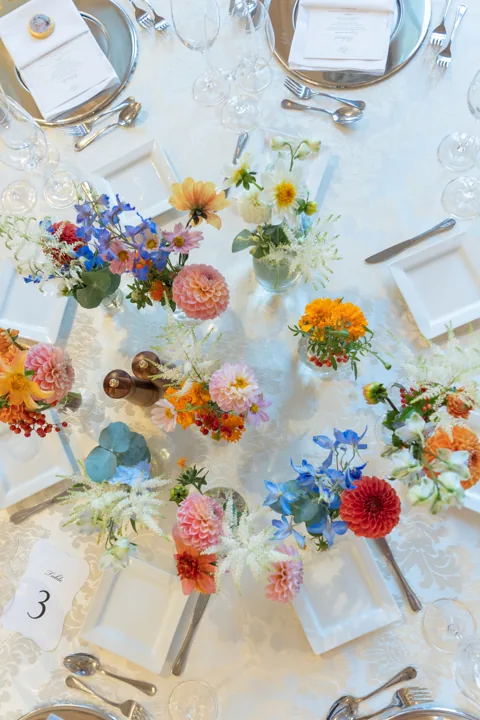 Festlich gedeckte Sommertafel von oben mit bunten Blumen im Conference Center Laxenburg