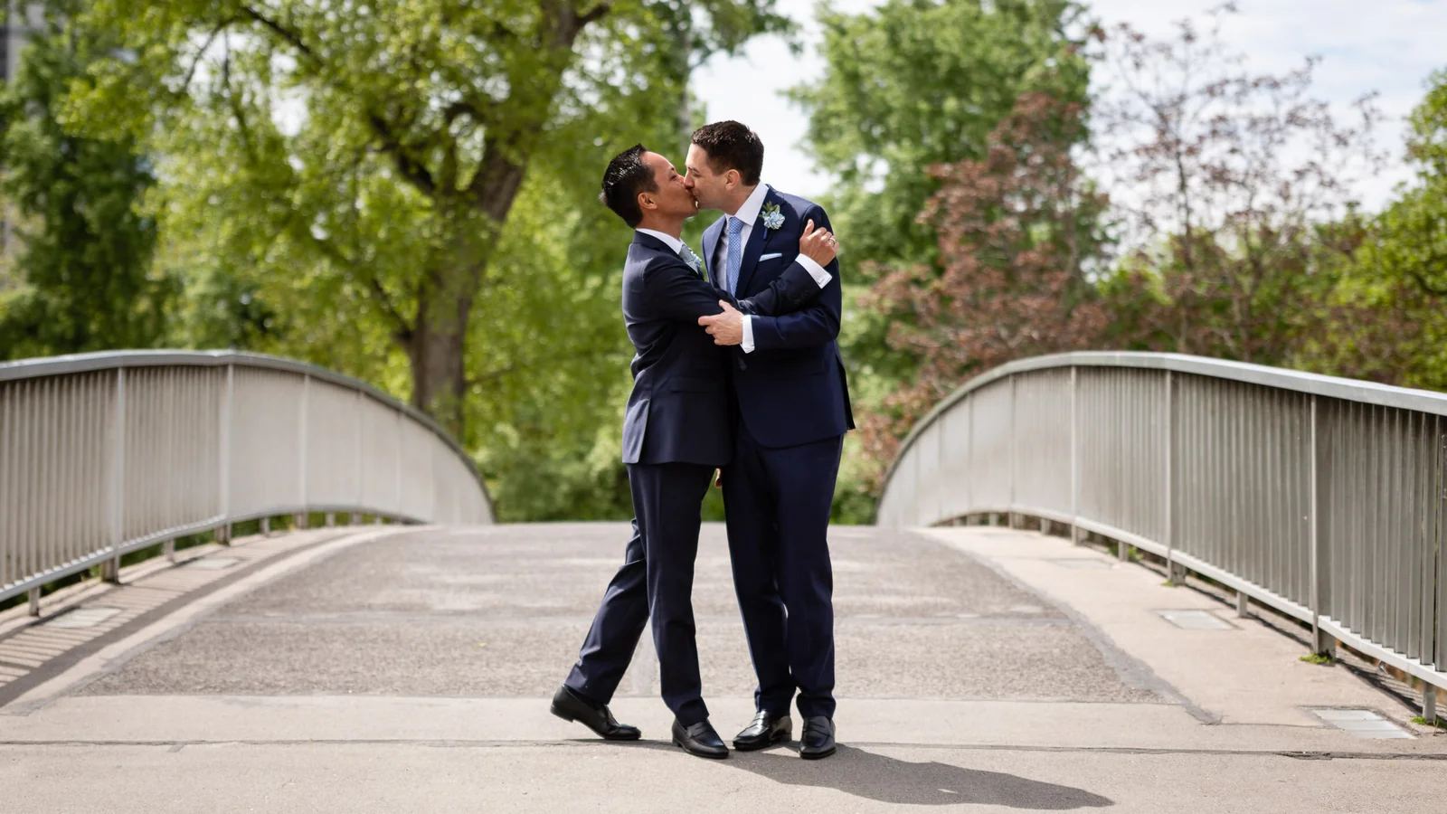 Hochzeitspaar aus zwei Männern küsst sich im Donaupark