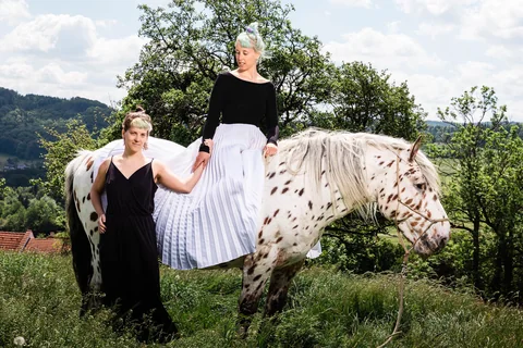 Weibliches Paar im Grünen mit Pferd