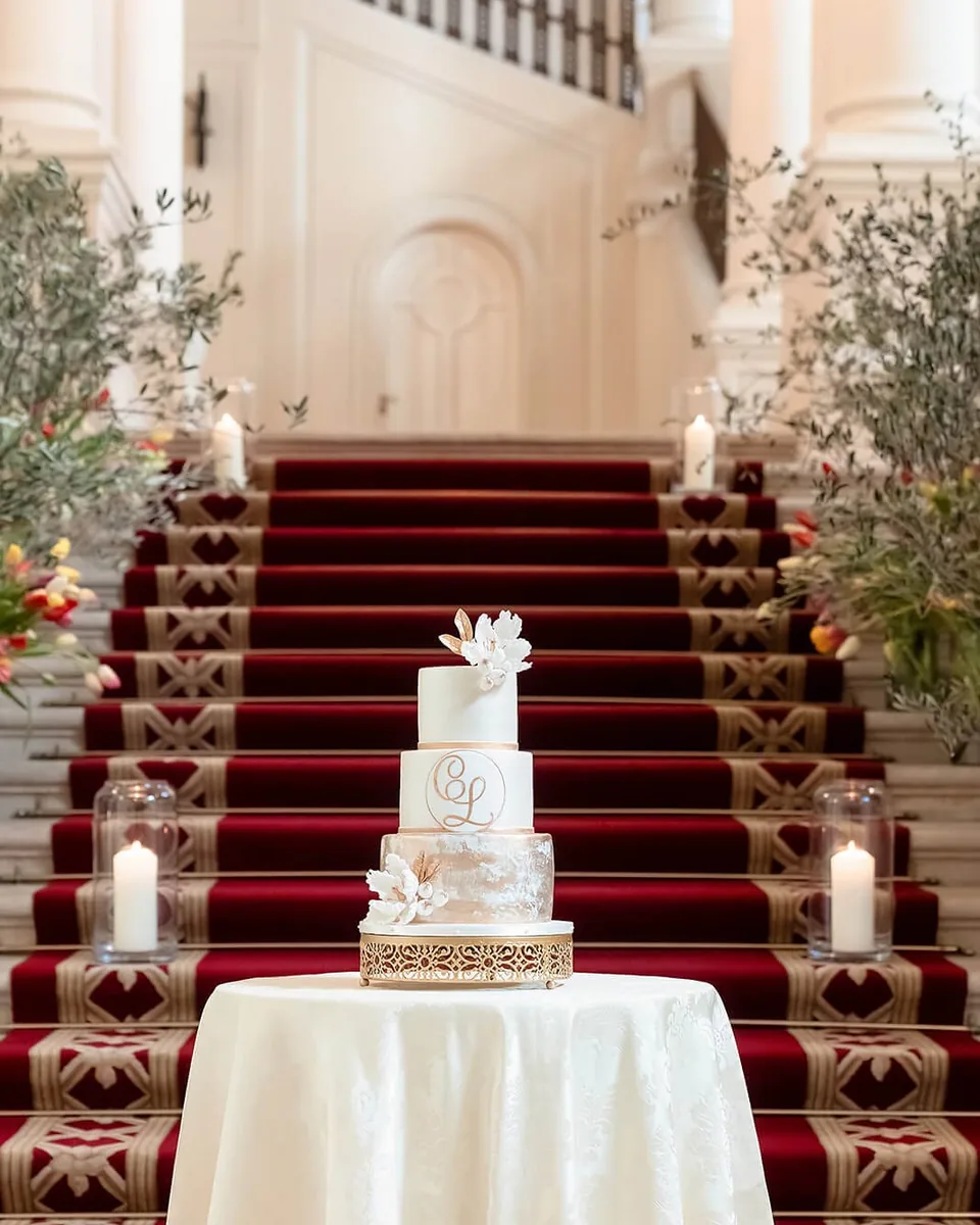 Multi-tier wedding cake in front of the red grand staircase of Palais Coburg