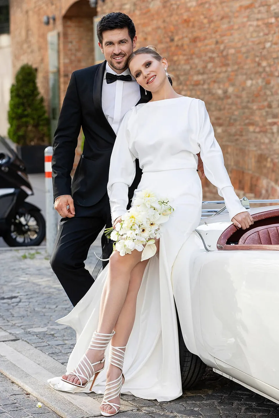 Wedding couple with a classic car in front of Palais Coburg