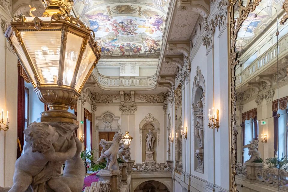 Barockes Stiegenhaus im Palais Daun-Kinsky in Wien mit Deckenfresko, Putten und Laterne