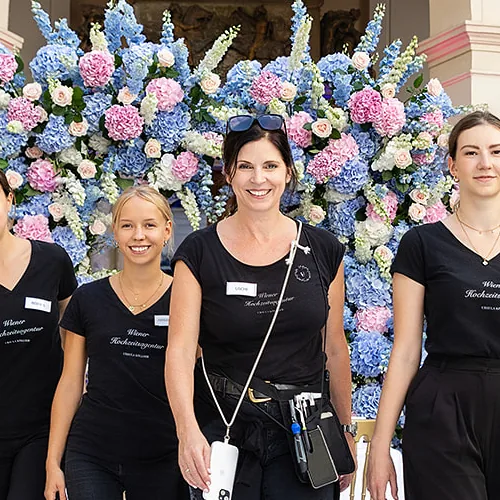 Ursula Köllner von der Wiener Hochzeitsagentur mit ihrem Team, vor dem Blumenbogen im Palais Niederösterreich