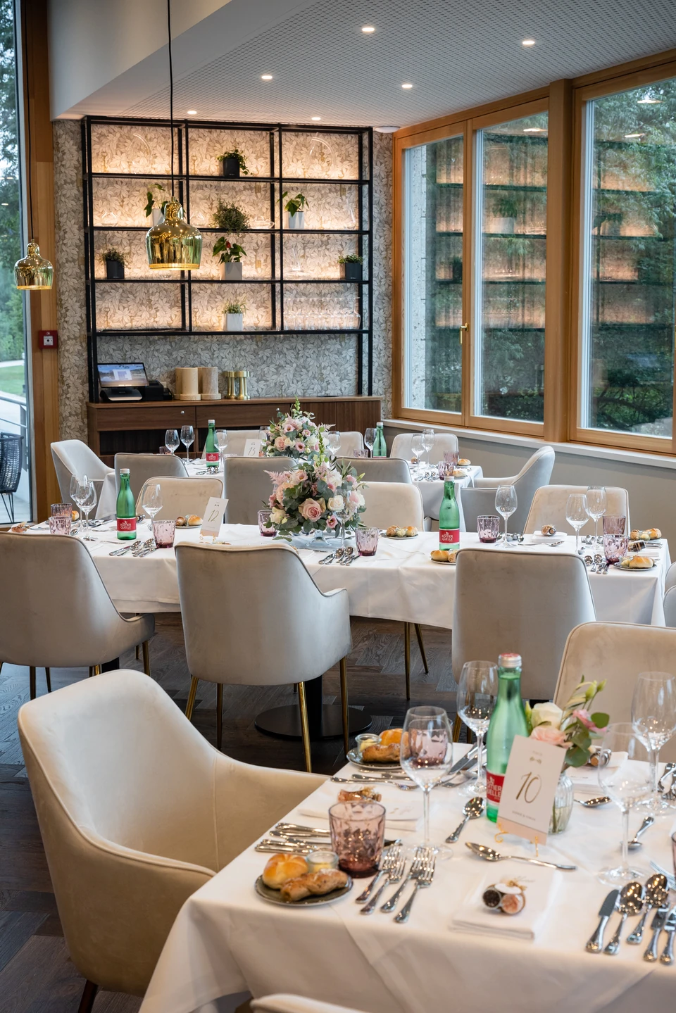 Festlich gedeckte Tische im modernen Restaurant des Gästeanbaus von Schloss Hernstein mit Panoramafenstern in den Park