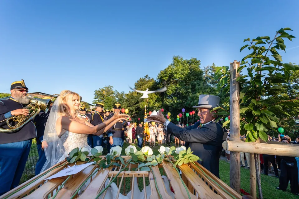 White doves rising above the wedding table in the garden of Schreiberhaus