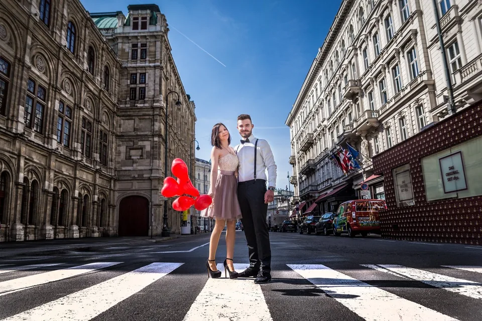 Paar mit Luftballons vor der Wiener Oper beim Verlobungsshooting