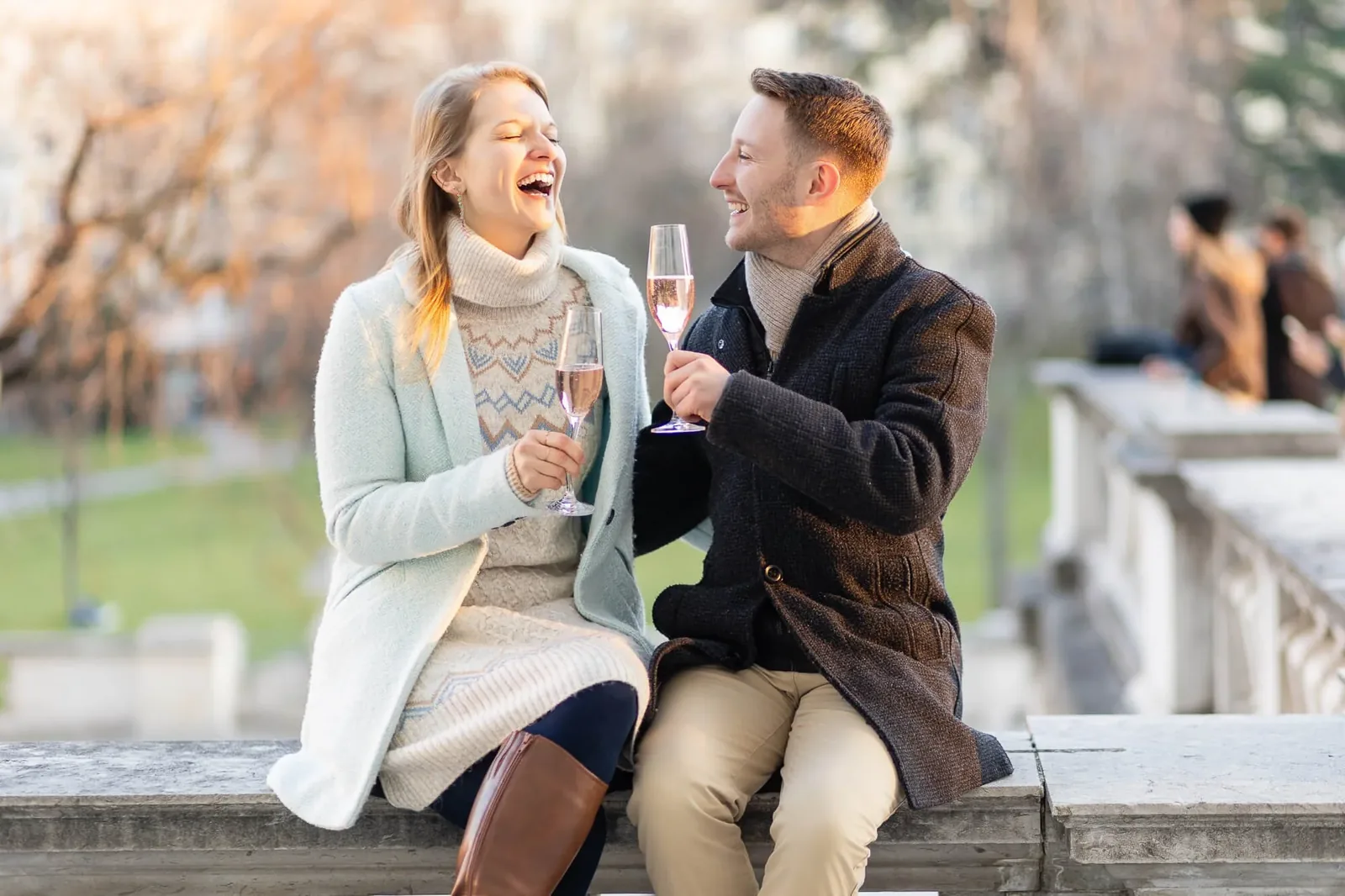 Frisch verlobtes Paar stößt im Burggarten Wien mit Champagner an