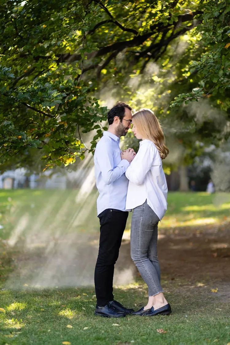 Couple in autumn morning mist with sun rays in the Burggarten