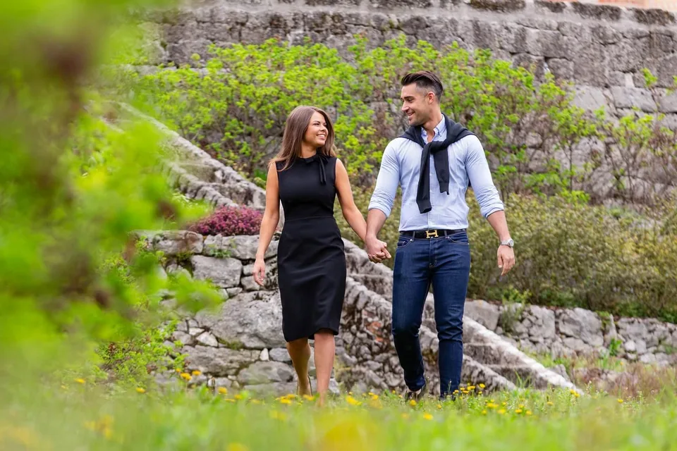 Engaged couple on stone steps amid greenery in Vienna