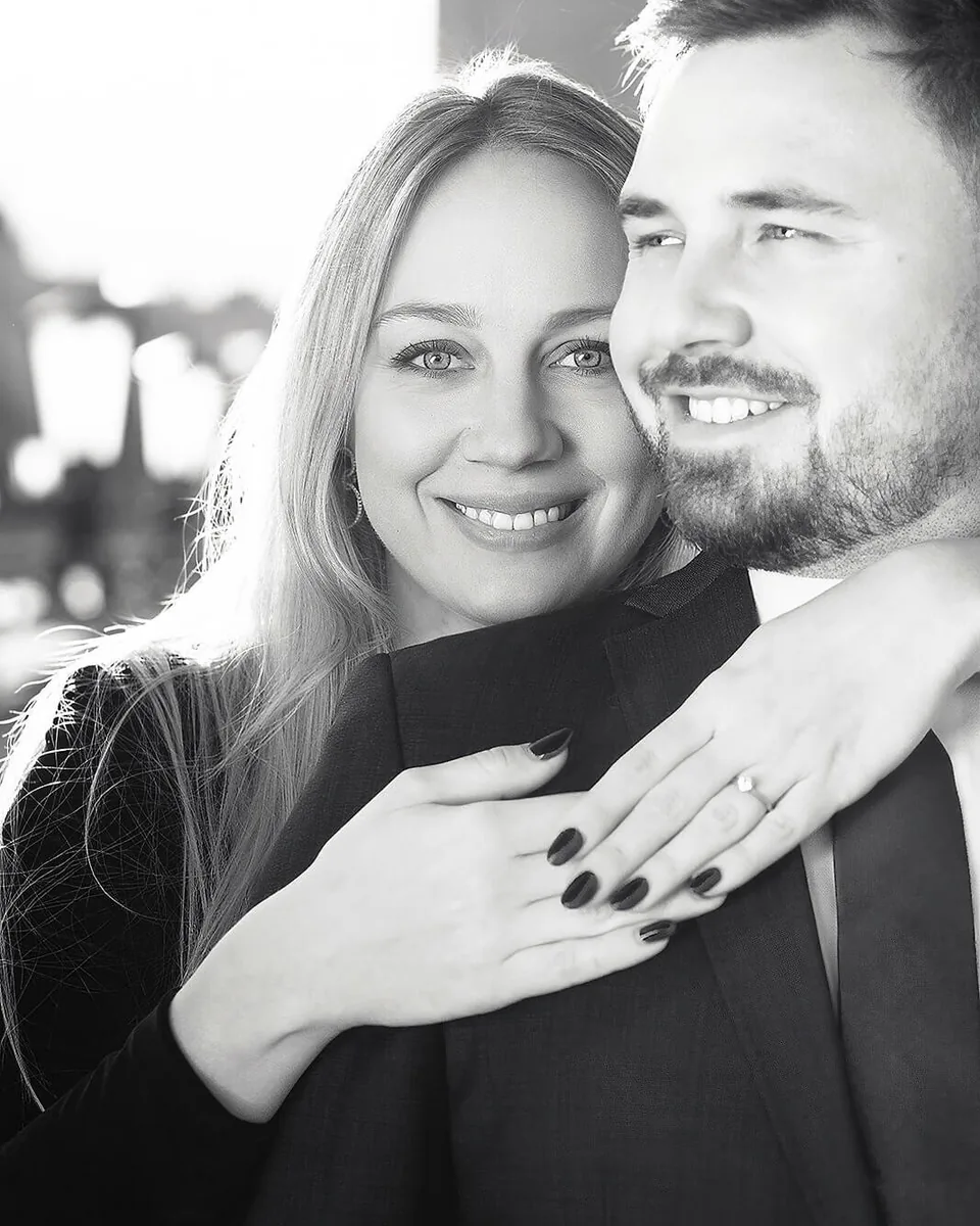 Elegant black-and-white photograph of an engaged couple embracing