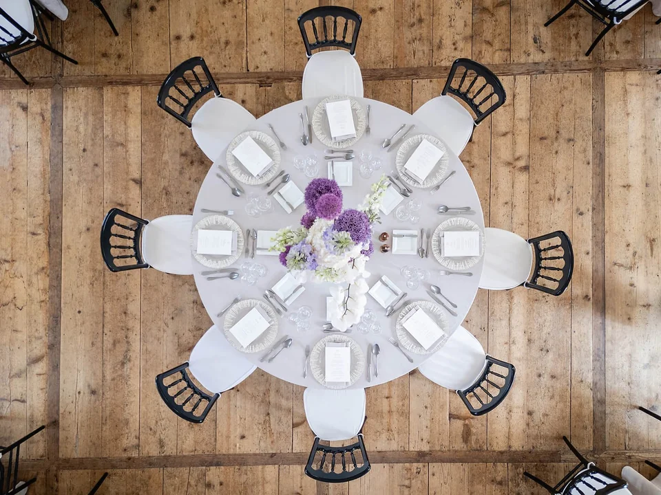 Runde Hochzeitstafel von oben mit violettem Blumenschmuck